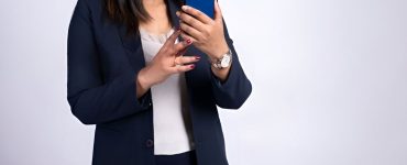 Woman using a smartphone to send WhatsApp bulk messages for business communication.